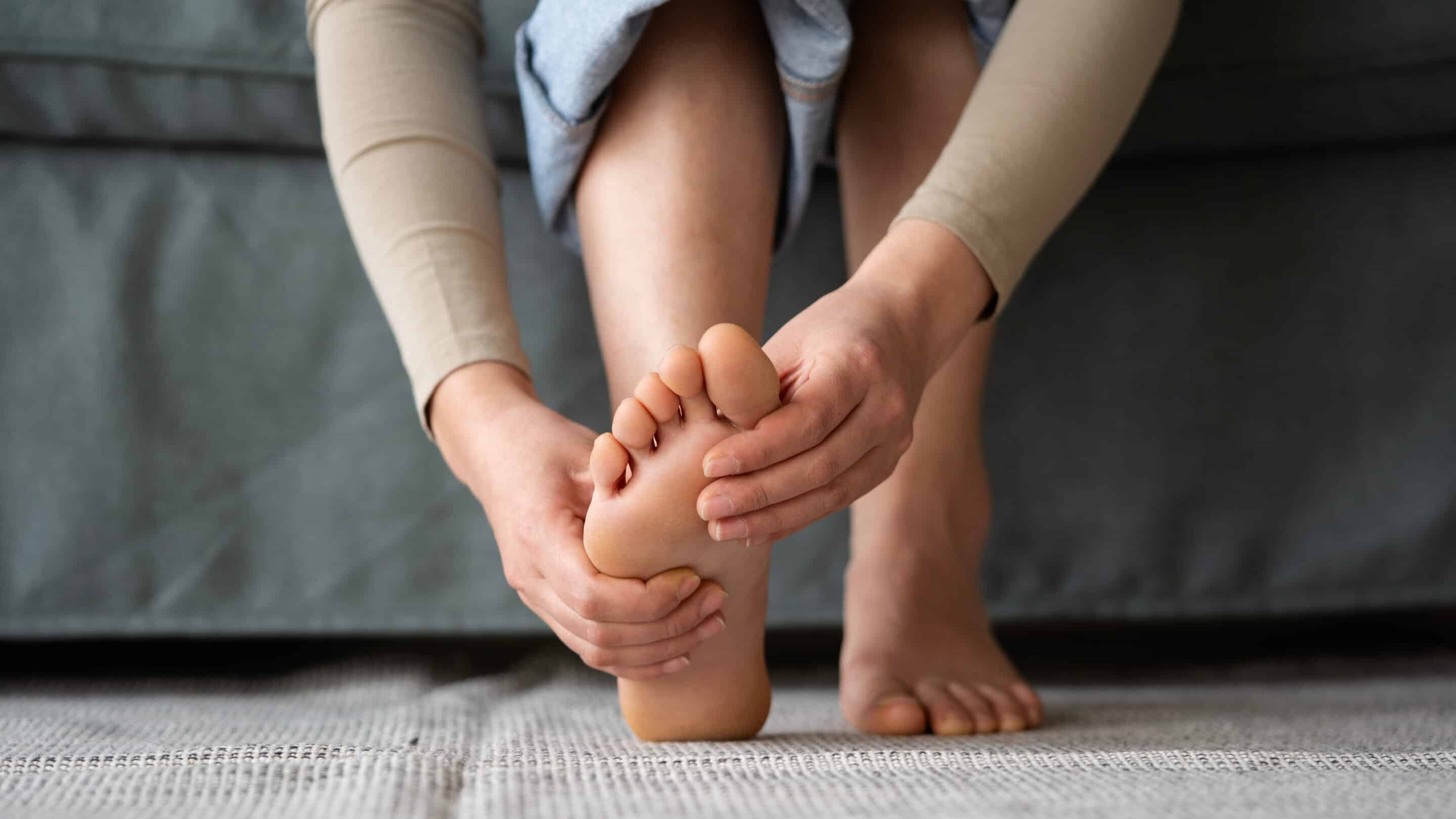 Young woman feeling pain in her foot